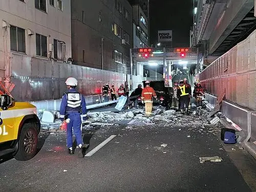 在大阪,一栋四层楼房的外墙倒塌,砸中了一辆行驶中的出租车,导 在大阪,一栋四层楼房的外墙倒塌,砸中了一辆行驶中的出租车,导
